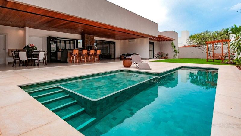 Área gourmet com piscina revestida em pedra natural — linhas trabalhadas pela Bene Acabamentos, Ijuí/RS
